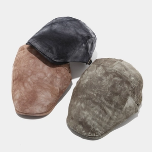 Detail of vintage tie-dye cotton flat caps with side metal adjustment buckles