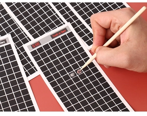 Close-up of Truth or Dare scratch cards with a wooden stylus on red background