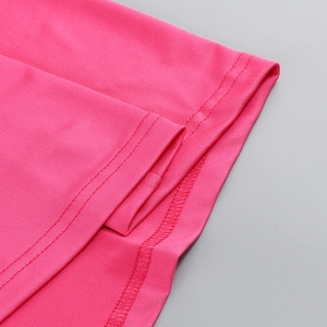 Detailed close-up of pink knit dress hem showing precise double-stitch craftsmanship