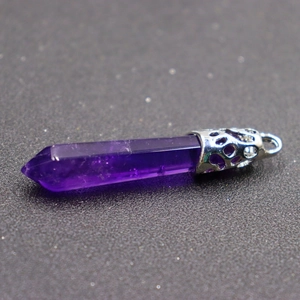 Close-up of a purple amethyst hexagonal prism pendant with a silver hollow metal clasp