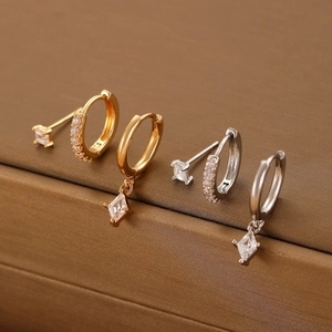 Detailed macro view of gold and silver diamond-shaped zircon earrings set for women