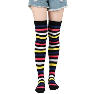 Detail of cotton over-knee socks featuring vibrant color stripes on a black base