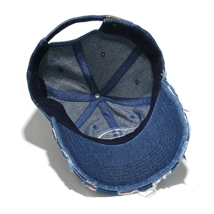 Detailed interior of blue denim baseball cap showing six-panel crown and metal strap buckle