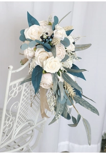 Close-up of a cascading bridal bouquet with white roses on a vintage metal chair