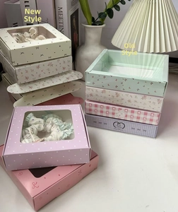 Detail of floral and polka dot gift boxes with transparent windows for hair accessories