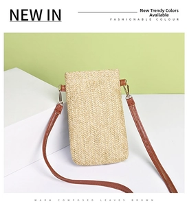 Detailed close-up of straw woven texture and brown leather strap on mobile phone bag