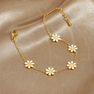 Golden daisy floral bracelet with white yellow enamel petals on a satin background