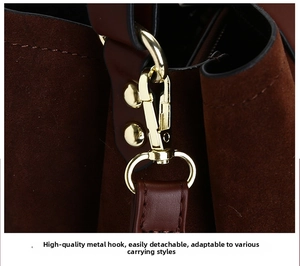 Close-up of high-quality gold hardware hook on a dark brown suede shoulder bag