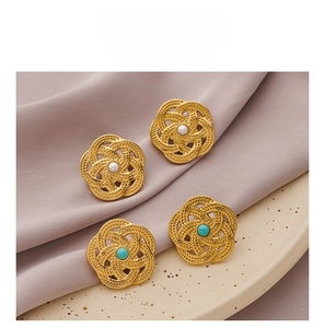 Macro dettagliata di orecchini a fiore vintage con perle e turchese in placcatura oro