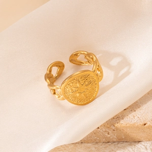 Détail d'une bague dorée en acier inoxydable avec étoile et anneau style gourmette