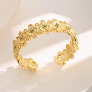 Luxurious gold daisy cuff bracelet with green zircon accents and textured floral design