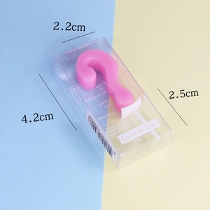 Pink question mark shaped birthday candle with dimensions on a blue and yellow background