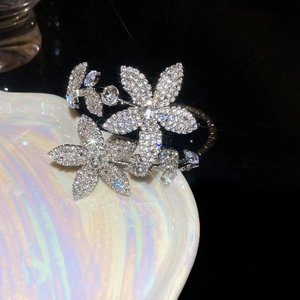 Detail of floral open cuff bracelet with sparkling crystal rhinestones on a shell tray