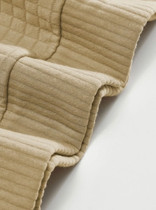 Detailed macro view of khaki knitted jacquard fabric texture on a long sleeve pullover