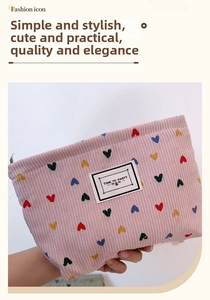 Detailed view of pink corduroy makeup bag with colorful heart embroidery and zipper