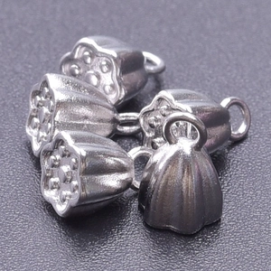 Cinq pendentifs lotus en acier inoxydable 304 argenté sur un fond noir à la texture détaillée
