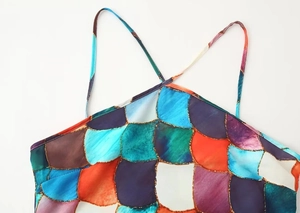 Detail of colorful geometric print sleeveless dress with slim crisscross shoulder straps