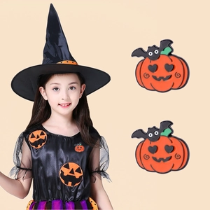 Detail of Halloween pumpkin and bat enamel pins showing wear on witch costume
