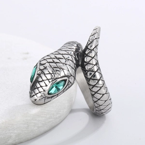 Macro shot of silver snake ring with green gem eyes and detailed scale texture