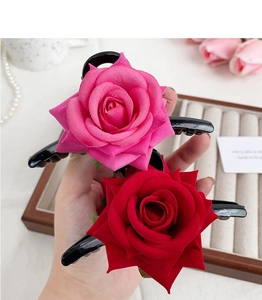 Elegant pink and red rose flower hair claws displayed in a stylish lifestyle setting