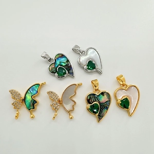 Detailed view of 18K gold plated heart and butterfly charms with abalone shell inlays