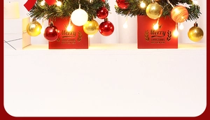 Mini lighted Christmas tree detail with red base and colorful baubles for table decoration