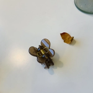 Vue détaillée d'une petite pince à cheveux papillon en marron translucide et ressort doré
