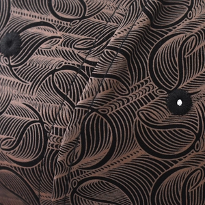 Vue macro du tissu à motif de losanges et œillets brodés sur une casquette chic