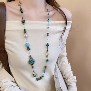 Bohemian long beaded necklace featuring irregular blue and brown glass beads on model