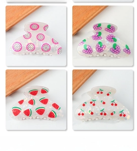 Close-up of pearlized acetate hair claws with fruit patterns like dragon fruit and cherry