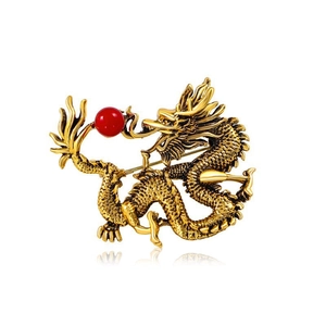 Vintage golden dragon brooch with red bead and detailed scales in a classic design