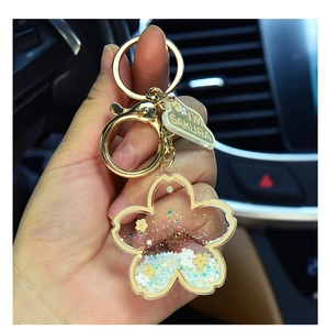 Detailed macro of cherry blossom acrylic keychain with moving blue liquid and glitter