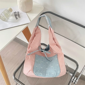 Close-up of pink checkered tote bag with blue contrast pocket and bow detail