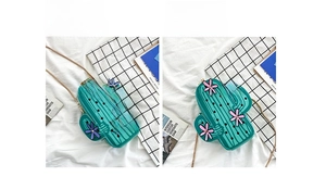 Detail view of two green cactus-shaped crossbody bags with pink and purple floral accents