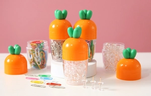 Creative carrot-shaped storage box with orange lid and green leaves for office pins