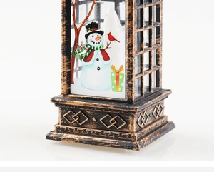 Close-up of vintage bronze Christmas lantern featuring snowman scene and brushed metal detail