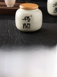 Macro detail of ash-glazed ceramic tea canister with calligraphy and wooden lid
