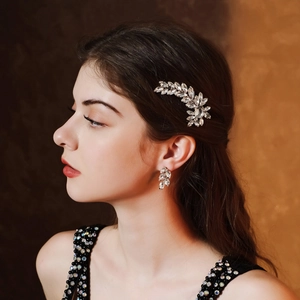 Detail of silver leaf hair clip and earrings with sparkling crystals on model