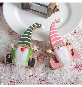 Detail of two wooden Christmas gnomes with striped hats and stars in a snowy festive scene