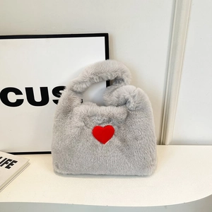 Detail shot of fluffy grey faux fur handbag featuring a vibrant red heart pattern motif