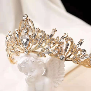 Luxury Baroque gold bridal crown with crystal rhinestones on a white Cupid statue base