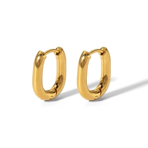 Close-up of gold oval huggie earrings with polished finish on a white background