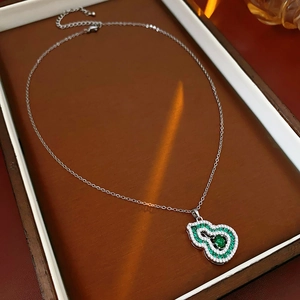 Macro shot of an emerald gourd pendant with crystals in a premium gift box