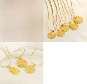 Close-up of gold stainless steel coin pendants including snake and relief designs