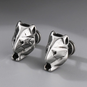 Macro shot of silver titanium steel wolf head stud earrings with a vintage metallic finish