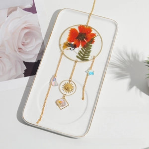 Close-up of dried flower sun catcher with golden charms and colorful crystal drops