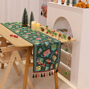 Detail of green Christmas table runner with gift patterns and colorful tassel edges