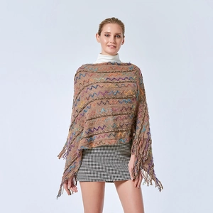 Détail d'un poncho en maille camel avec motifs de vagues colorés, torsades et franges