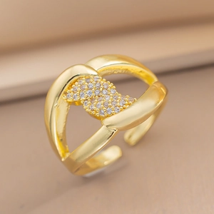 Detail of adjustable gold ring with sparkling cubic zirconia on champagne background