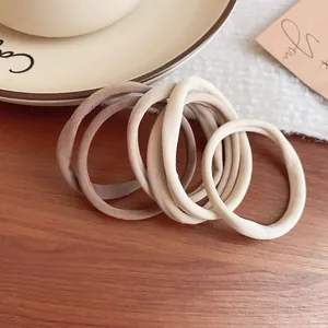 Set of 5 elastic earth-tone fabric hair ties displayed on a rustic wooden surface